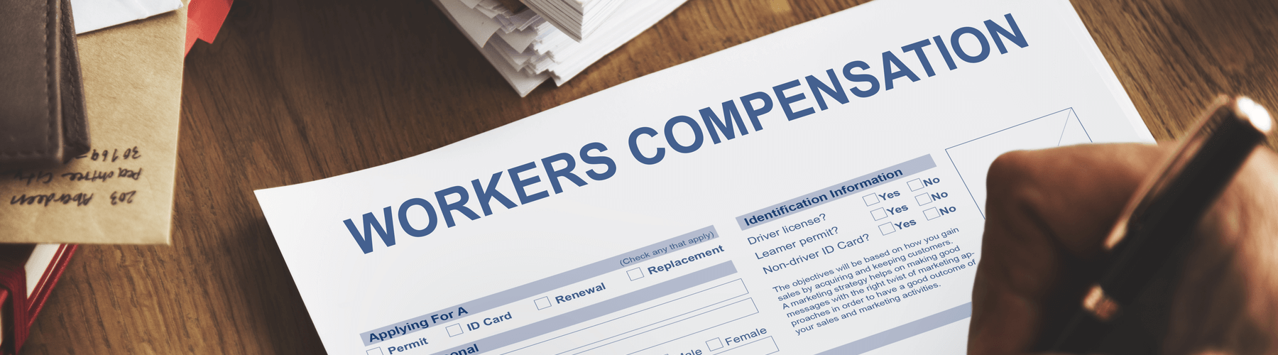 Individual filling out paper for workers compensation at desk